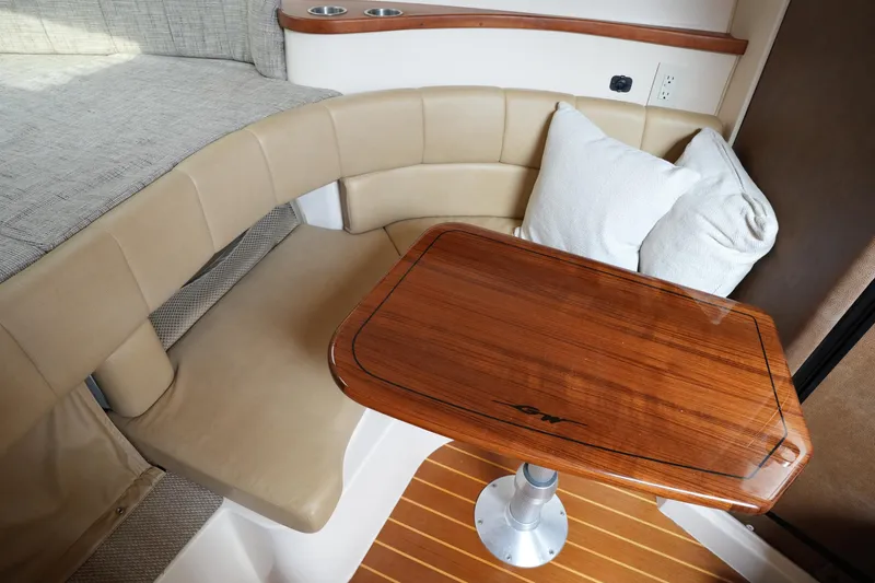 Slide: The Image of 2009 Grady-White Express 330 cabin interior with cushioned seating and wooden table. - 54