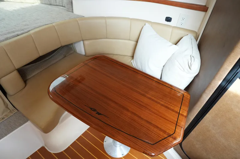 Slide: The Image of 2009 Grady-White Express 330 interior with cushioned seating and wooden table. - 57