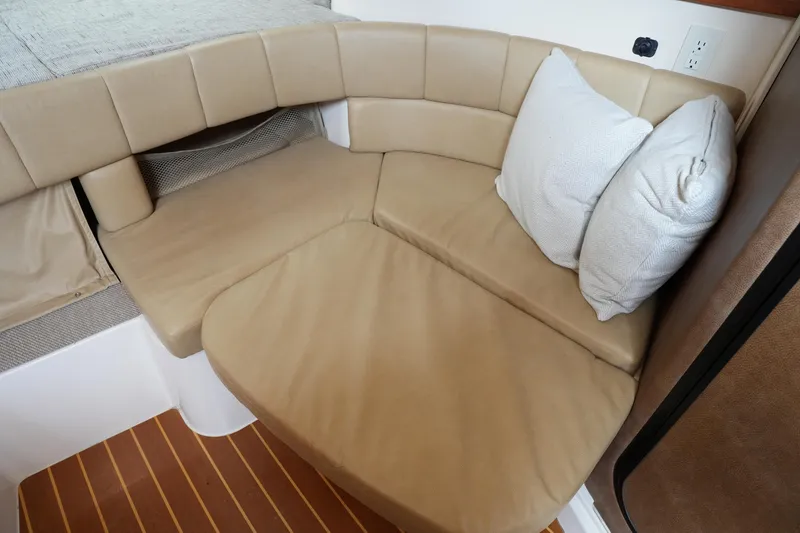 Slide: The Image of 2009 Grady-White Express 330 cabin interior with beige seating and cushions. - 58