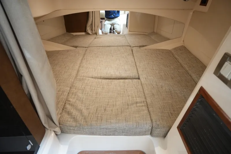 Slide: The Image of 2009 Grady-White Express 330 cabin interior with beige cushions and compact layout. - 59