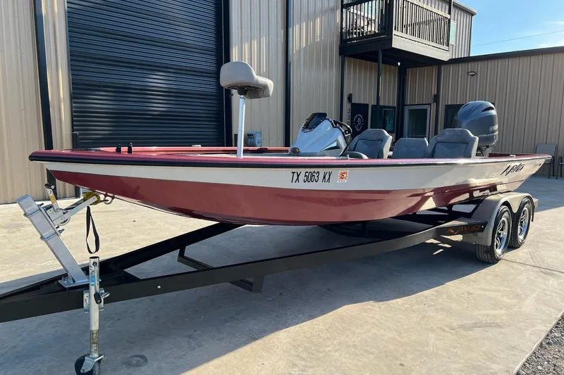 Slide: The Image of 2024 Avid 20 XB boat on trailer, parked outside a building. - 2