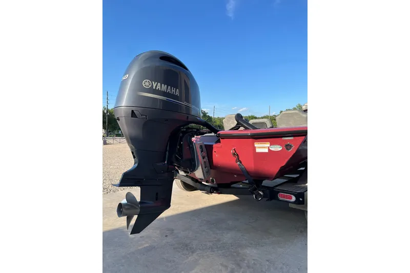 Slide: The Image of 2024 Avid 20 XB boat with Yamaha outboard motor, parked outdoors under clear blue sky. - 20