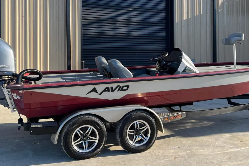 Slide: The Image of 2024 Avid 20 XB boat on trailer, parked outside a building. - 3