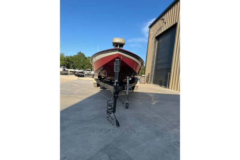 Slide: The Image of 2024 Avid 20 XB boat on trailer outside a large garage. - 4