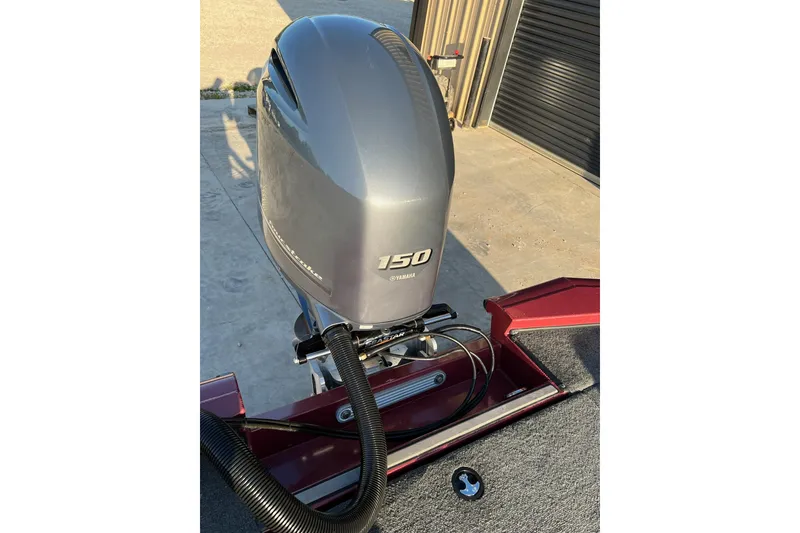Slide: The Image of 2024 Avid 20 XB boat with Yamaha 150 outboard motor, parked outdoors. - 9