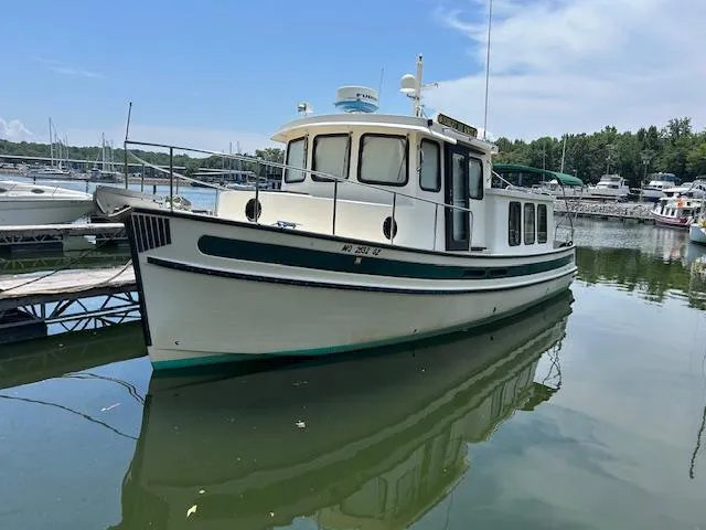 Slide: The Image of 2001 Nordic Tug 32 boat docked in a marina on a sunny day. - 1