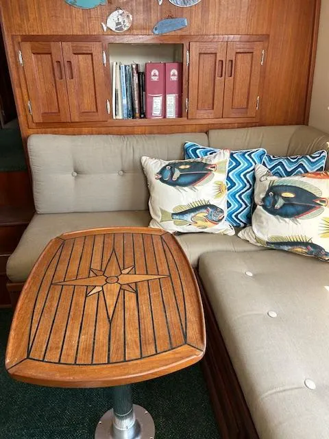Slide: The Image of Cozy Nordic Tug 32 interior with wooden table, cushioned seating, and decorative pillows. - 5