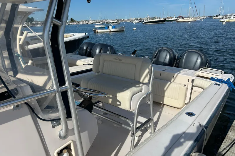 Slide: The Image of 2004 Grady-White Chase 273 boat docked, featuring dual outboard engines and spacious seating. - 10