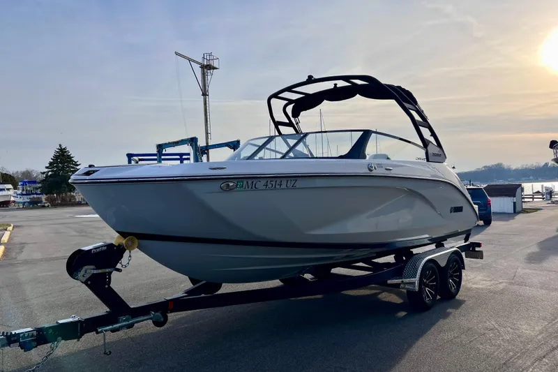 Slide: The Image of 2024 Yamaha Boats 222SD on trailer at marina, under a clear sky. - 7