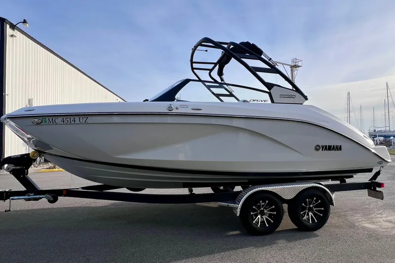 Slide: The Image of 2024 Yamaha Boats 222SD on trailer, sleek design, parked outdoors. - 8