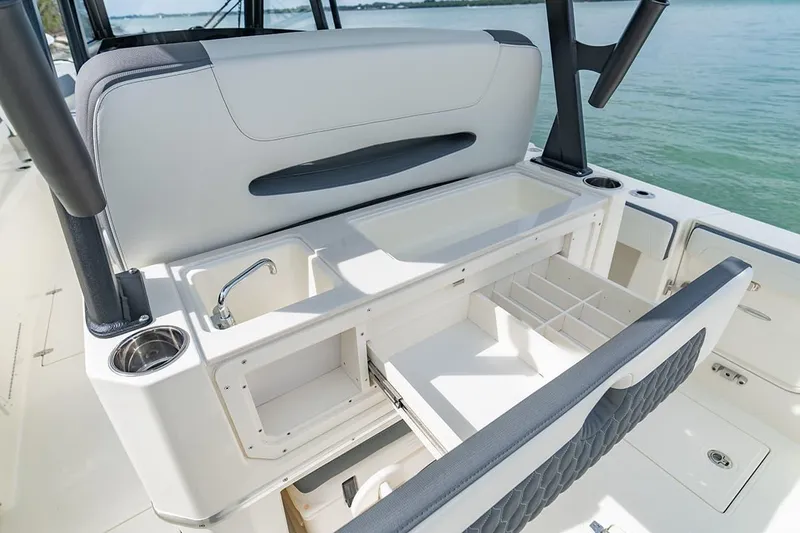 Slide: The Image of 2026 Cobia 305 Center Console boat interior with storage compartments and sink. - 10