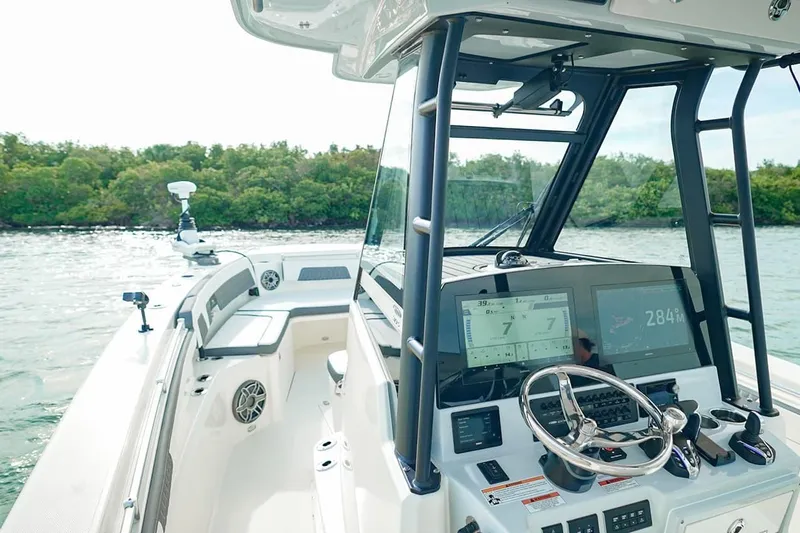 Slide: The Image of 2026 Cobia 305 Center Console boat interior with advanced navigation system and steering wheel. - 12