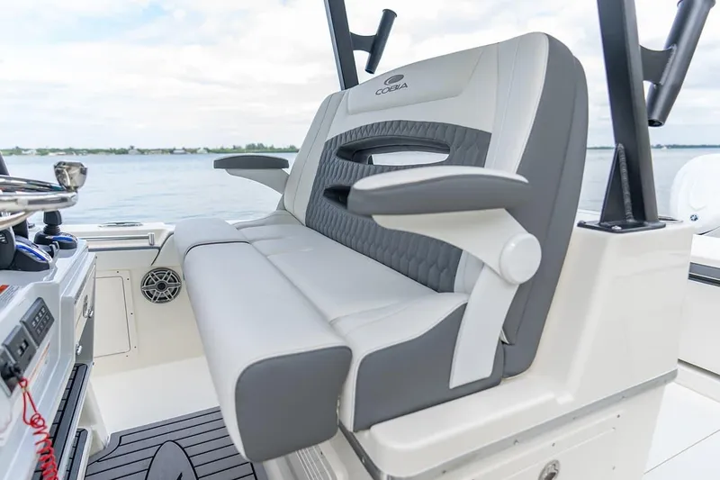 Slide: The Image of 2026 Cobia 305 Center Console boat seating with armrests, overlooking calm waters. - 13