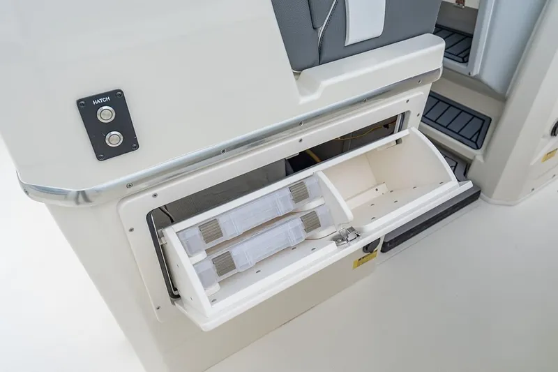 Slide: The Image of Storage compartment on 2026 Cobia 305 Center Console boat with hatch button. - 16