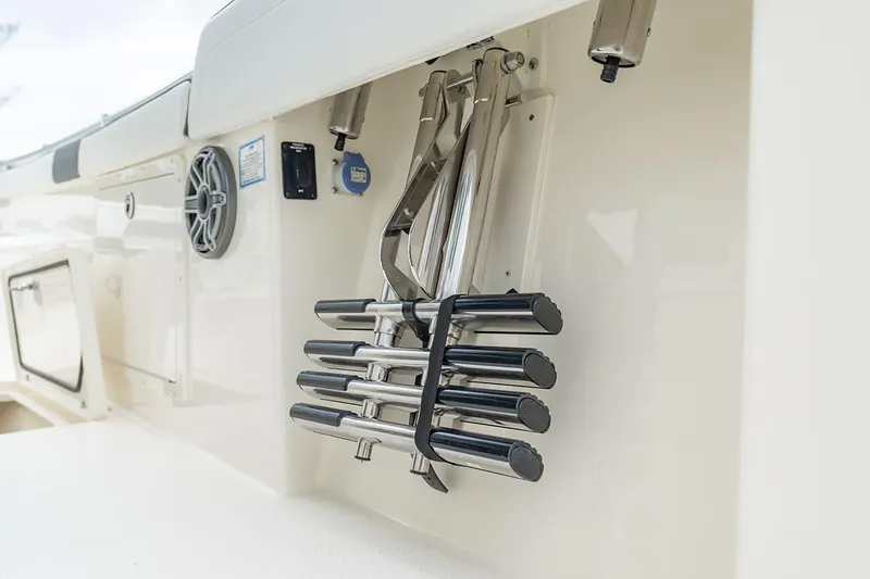 Slide: The Image of 2026 Cobia 305 Center Console boat interior with rod holders and speaker. - 17