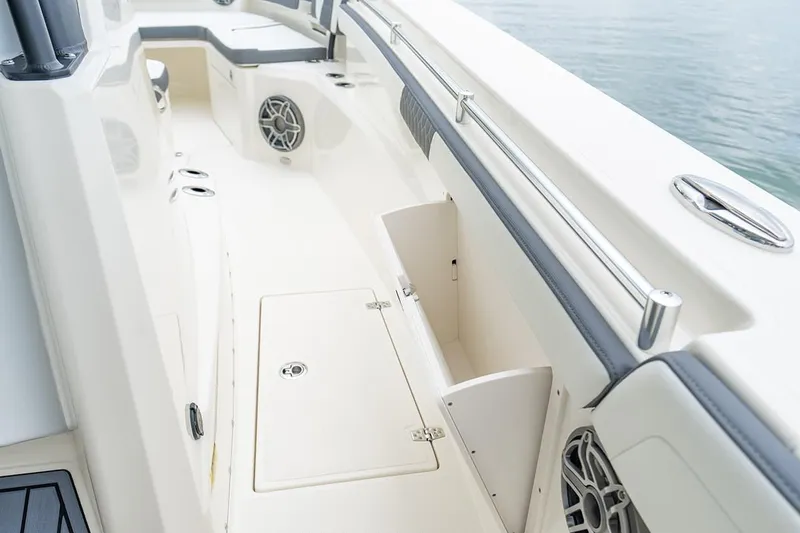 Slide: The Image of 2026 Cobia 305 Center Console boat interior with storage compartments and speakers. - 18