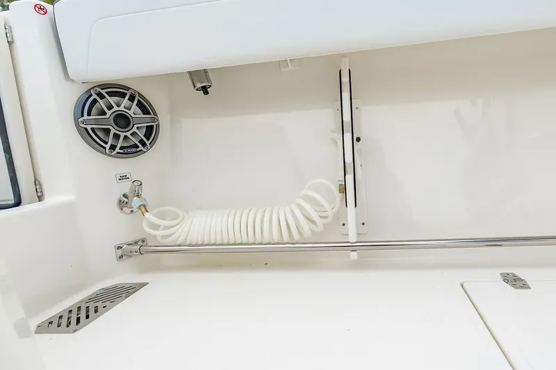 Slide: The Image of 2026 Cobia 305 Center Console boat interior with speaker and coiled hose. - 29