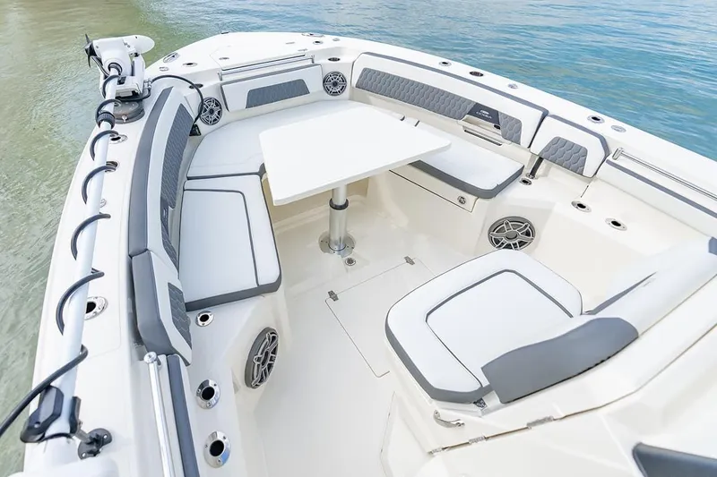 Slide: The Image of 2026 Cobia 305 Center Console boat interior with seating and table on calm water. - 32