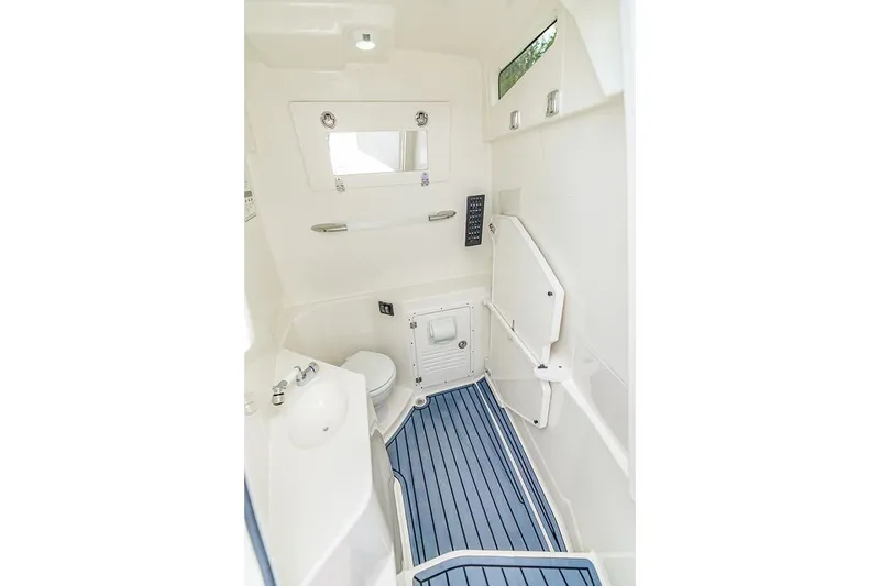 Slide: The Image of Interior of 2026 Cobia 305 Center Console boat, featuring a compact, modern bathroom. - 38