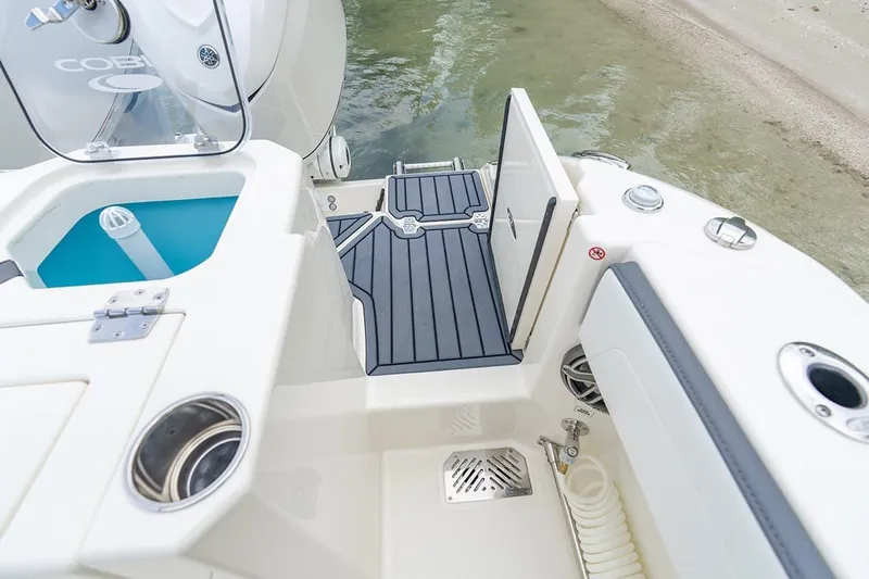 Slide: The Image of 2026 Cobia 305 Center Console boat deck with open hatch and water access. - 5
