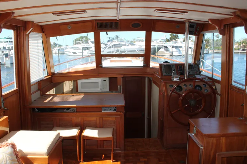 Slide: The Image of Interior of 1987 Grand Banks 42 Motoryacht with wooden helm and marina view. - 14