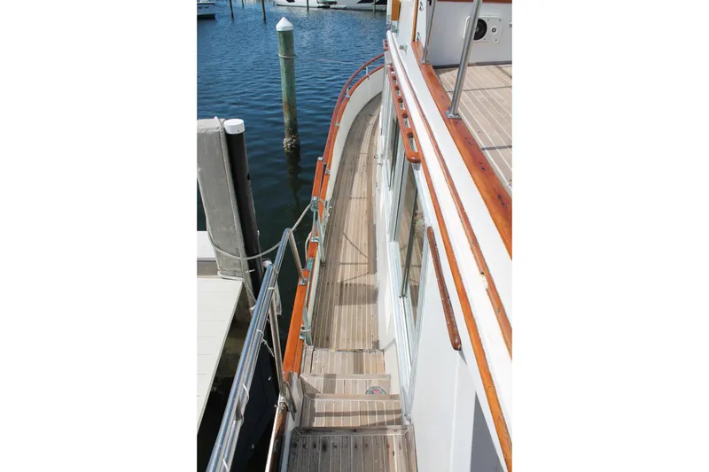 Slide: The Image of 1987 Grand Banks 42 Motoryacht deck with wooden railings and marina view. - 3