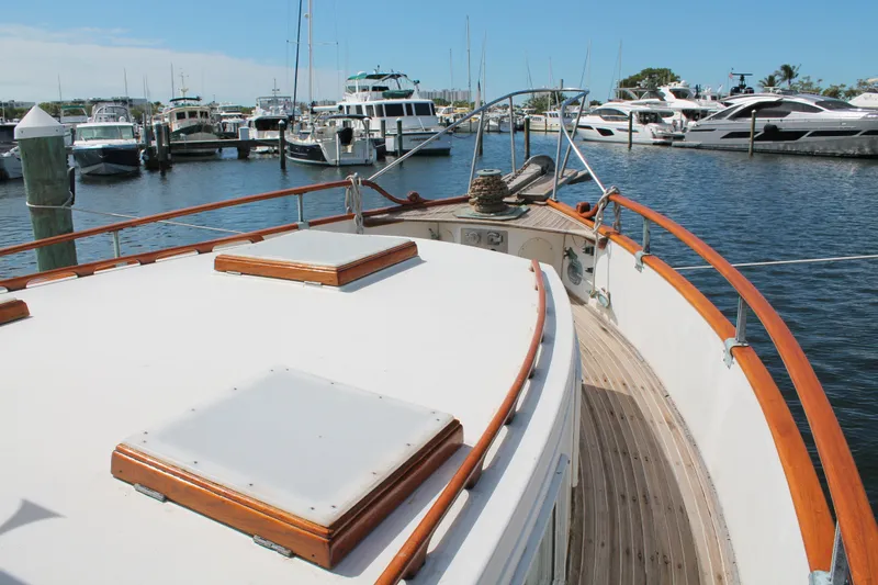 Slide: The Image of 1987 Grand Banks 42 Motoryacht docked in a marina, showcasing its classic wooden deck. - 7