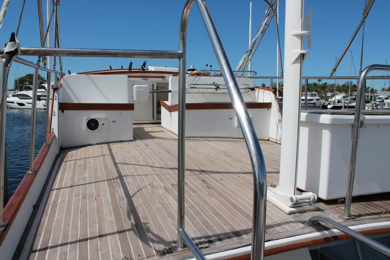 Slide: The Image of 1987 Grand Banks 42 Motoryacht deck with railing, docked at marina under clear blue sky. - 8