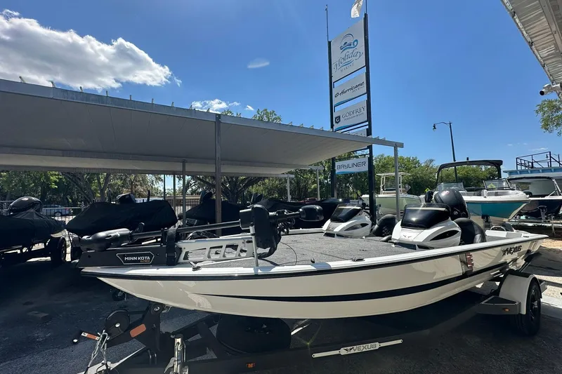 The Image of 2026 Vexus AVX1880 boat displayed at dealership under clear blue sky. - 1