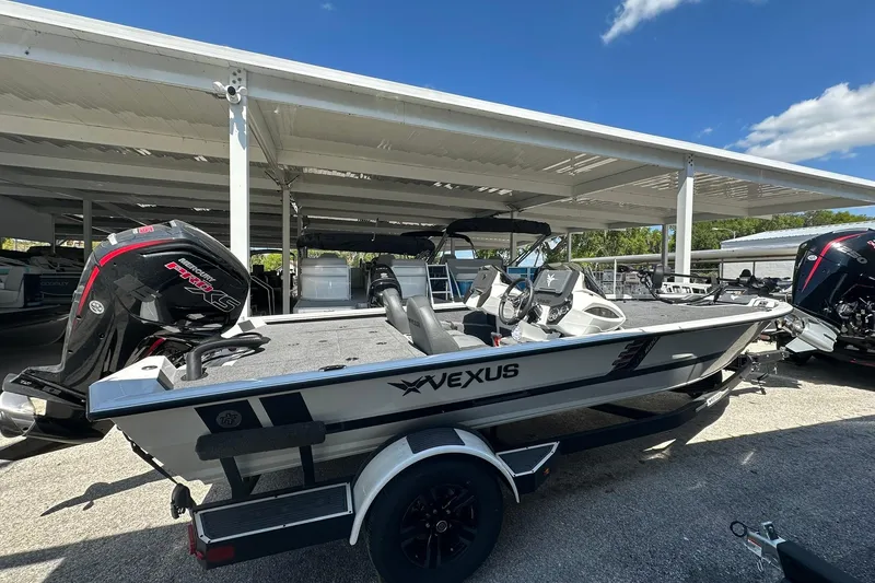 Slide: The Image of 2026 Vexus AVX1880 boat with Mercury Pro XS engine, parked under a canopy. - 2
