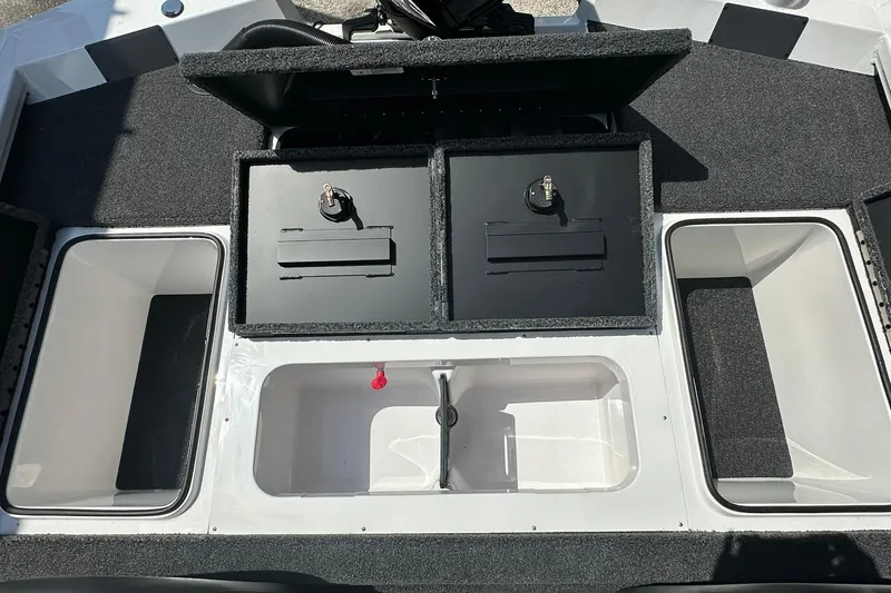 Slide: The Image of 2026 Vexus AVX1880 boat storage compartments with open lids and carpeted surfaces. - 27