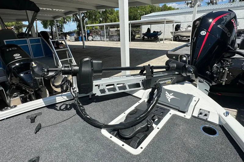 Slide: The Image of 2026 Vexus AVX1880 boat with Minn Kota trolling motor in a marina setting. - 6