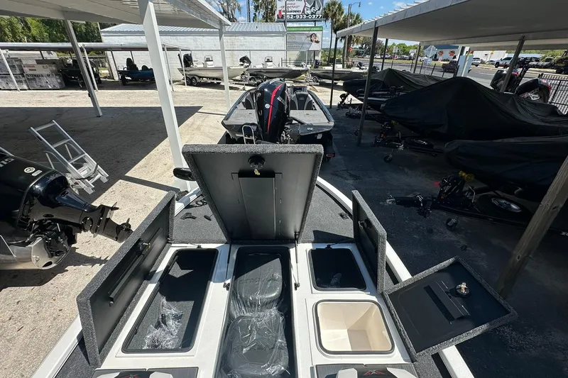 Slide: The Image of 2026 Vexus AVX1880 boat with open storage compartments in a covered parking area. - 9