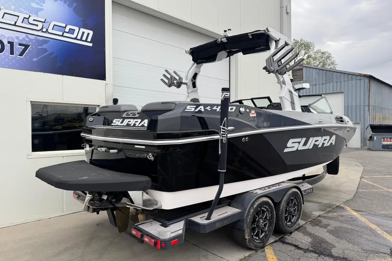 Slide: The Image of 2024 Supra SA 450 boat on trailer, parked outside a building. - 3