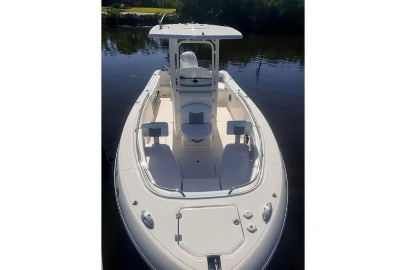 Slide: The Image of 2020 Robalo R242 Explorer boat on calm water, showcasing sleek design and spacious deck. - 6