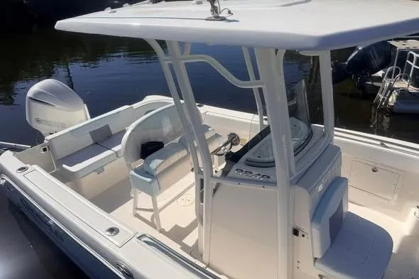 Slide: The Image of 2020 Robalo R242 Explorer boat with seating and console, docked on calm water. - 9