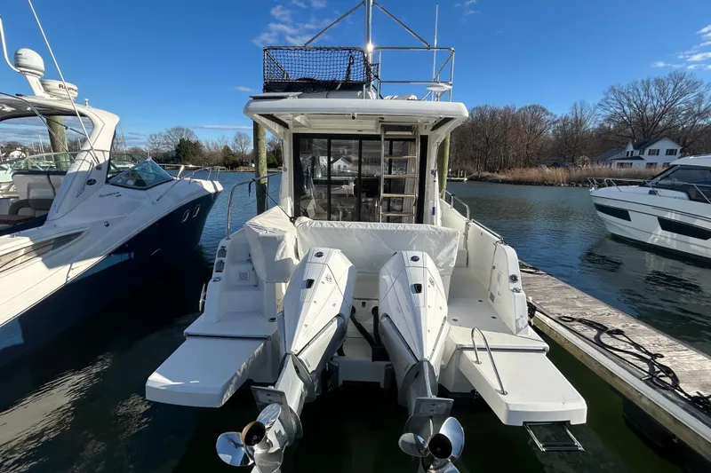 Slide: The Image of 2025 Beneteau Antares 11 Fly moored at a marina, featuring dual outboard engines. - 3