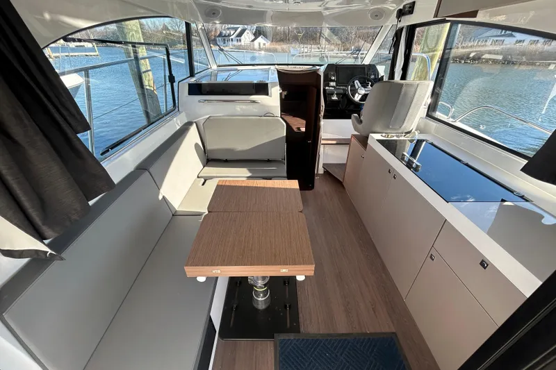 Slide: The Image of Interior of 2025 Beneteau Antares 11 Fly, featuring modern seating and helm, with waterfront view. - 4
