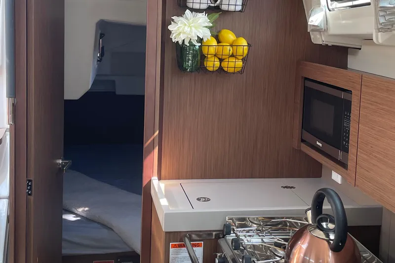 Slide: The Image of Interior of 2022 Beneteau Oceanis 38.1 yacht galley with stove, microwave, fridge/freezer and sink - 10