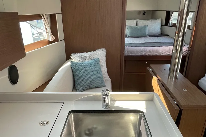 Slide: The Image of Interior of 2022 Beneteau Oceanis 38.1 yacht, featuring modern galley and cozy vee berth - 11