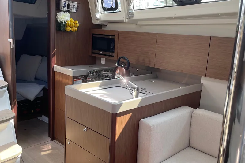 Slide: The Image of Interior of 2022 Beneteau Oceanis 38.1 yacht with modern galley and cozy seating area - 12