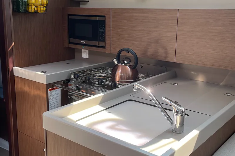 Slide: The Image of Modern galley in 2022 Beneteau Oceanis 38.1 yacht with stove, sink, and microwave - 13