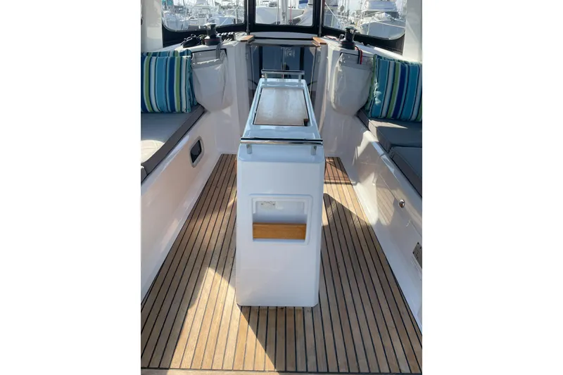 Slide: The Image of 2022 Beneteau Oceanis 38.1 yacht cockpit with striped cushions and teak flooring. - 35
