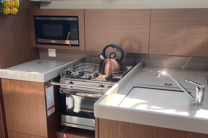 Slide: The Image of Modern galley in 2022 Beneteau Oceanis 38.1 yacht with stove, microwave, fridge/freezer, and sink - 5