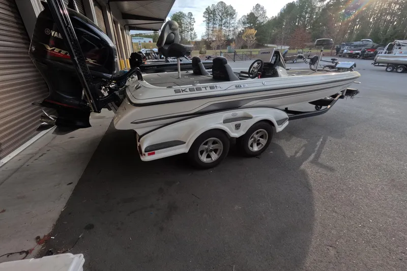 The Image of 2015 Skeeter FX21 boat on trailer with Yamaha outboard motor, parked outdoors. - 1