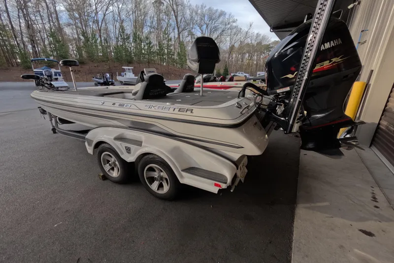 Slide: The Image of 2015 Skeeter FX21 boat with Yamaha motor on a trailer, parked outdoors. - 4