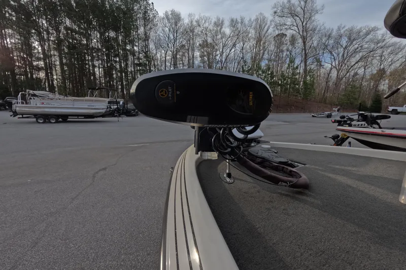 Slide: The Image of 2015 Skeeter FX21 boat with trolling motor in a wooded parking area. - 7