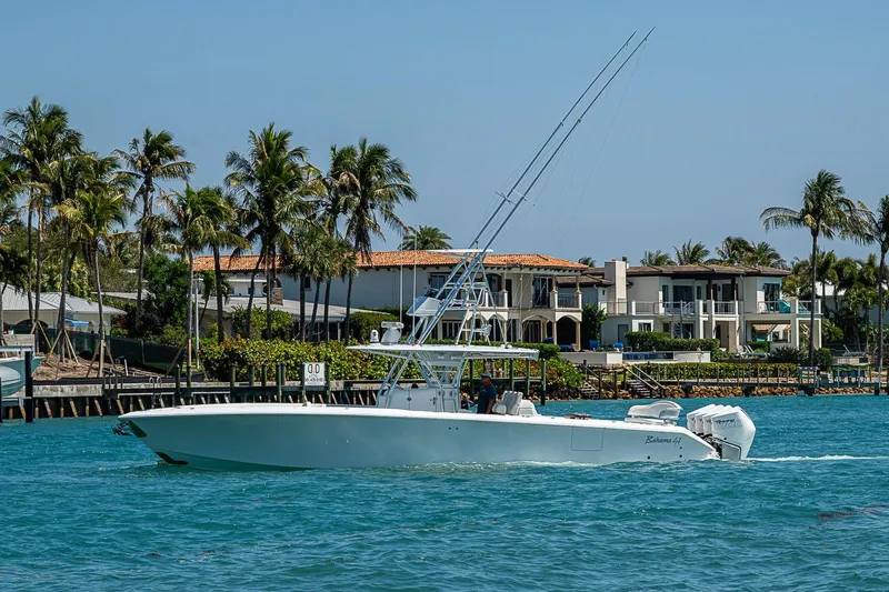 Slide: The Image of 2017 Bahama 41 boat cruising on turquoise water near luxury waterfront homes. - 11