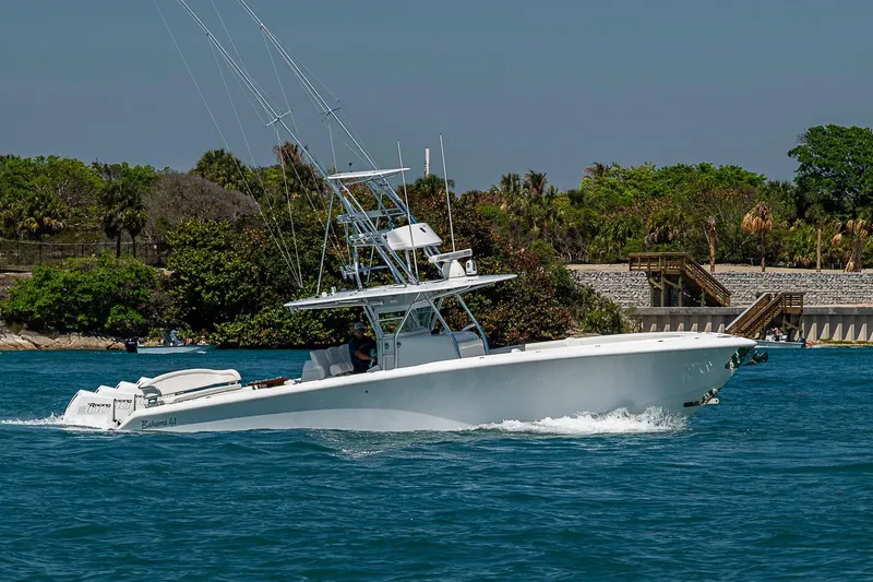 Slide: The Image of 2017 Bahama 41 boat cruising on blue water near lush shoreline. - 12