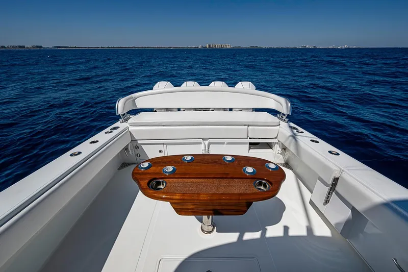 Slide: The Image of 2017 Bahama 41 boat with wooden table, white seating, and ocean view. - 16